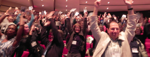 People with hands in air during conference